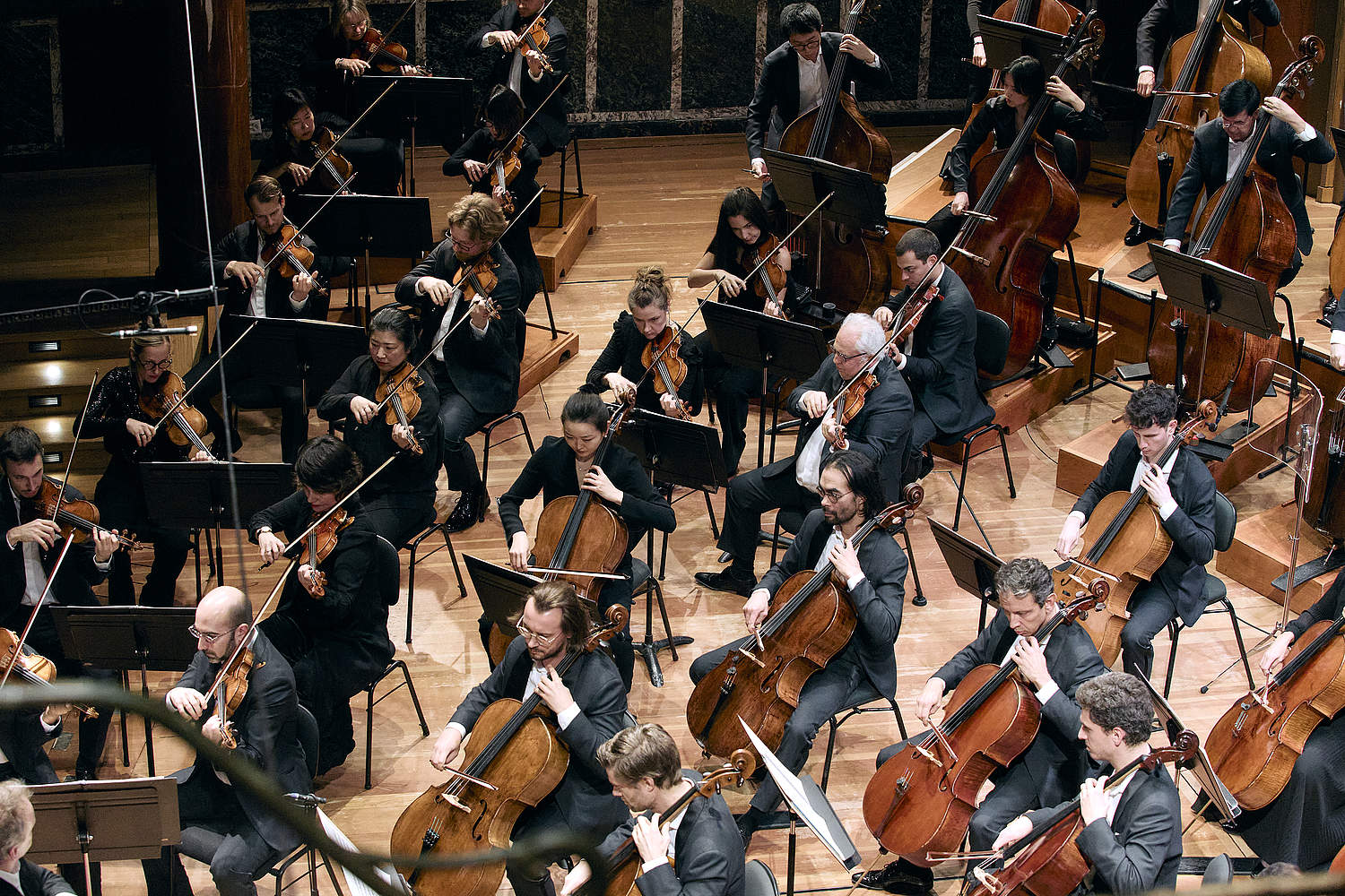 Pupitres des premiers violons et violoncelles de l'Orchestre de la Suisse Romande jouant le Sacre du Printemps lors d'un concert au Victoria Hall en février 2025
