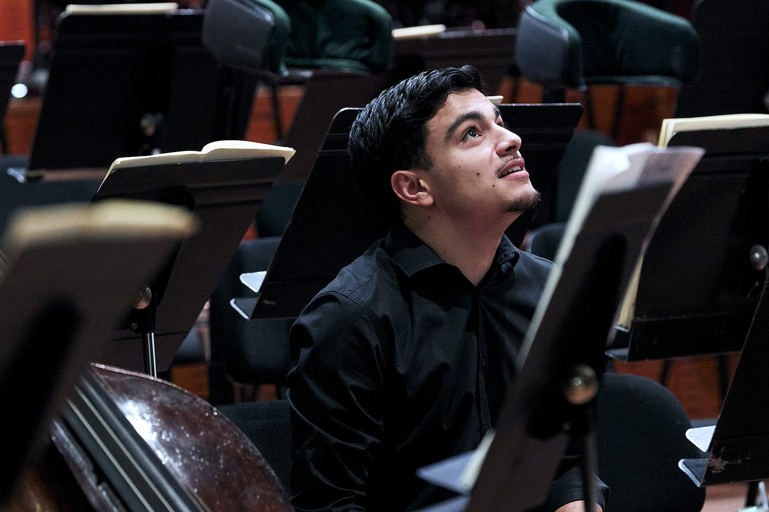 Jeune musicien de la Haute École de Musique de Genève, regardant vers le haut en souriant lors du concert du 10 décembre avec l'Orchestre de la Suisse Romande et la cheffe Eva Ollikainen